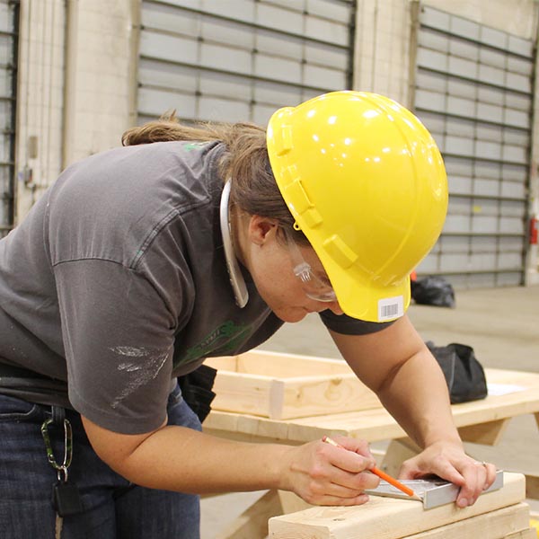 Carpentry student measuring wood